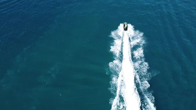 unrecognizable people on jetsky and a few boats