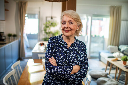 Confident senior woman standing at home looking at camera