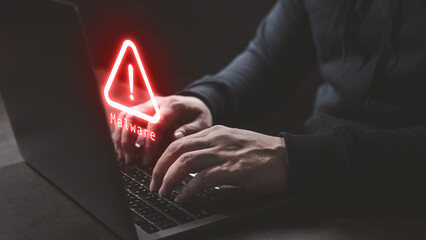 Hacker wear hood using computer laptop with red warning icon to launch ransomware malware attack on...