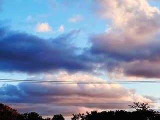 Orange and pink sky at sunset with a backdrop of cloudy white clouds
