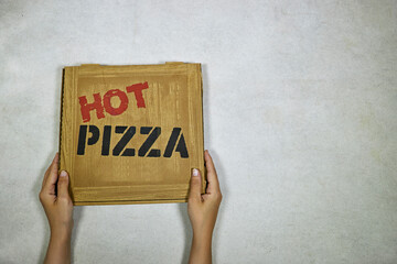 Hands hold box with tasty pizza, top view
