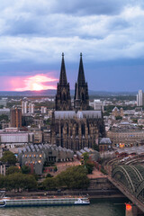 Obraz premium Dramatic storm clouds over Cologne Cathedral and Hohenzollern Bridge in the sunset