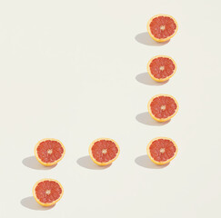 Fresh grapefruit halves geometrically laid out on a beige background with copy space. Flat lay. Minimal geometrical pattern. Creative minimal concept.