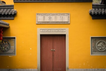 Inviting red door on the front of a bright yellow building