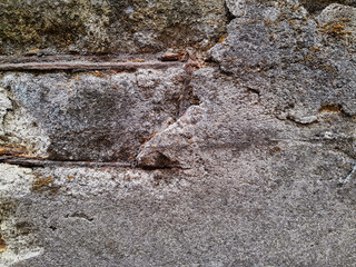 Grungy wall of gray concrete texture with cracked surface from sand and cement materials.
