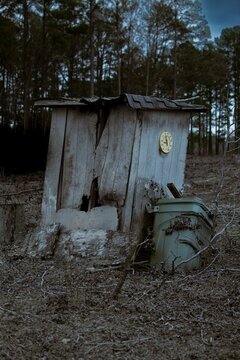 Broken wooden toilet in a wooded area
