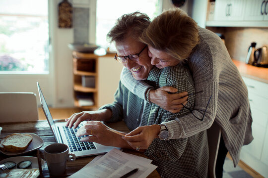 Mature couple online shopping with laptop at home