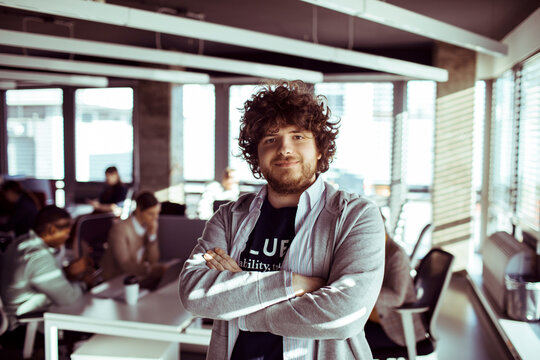 Portrait of a young man looking at camera in office