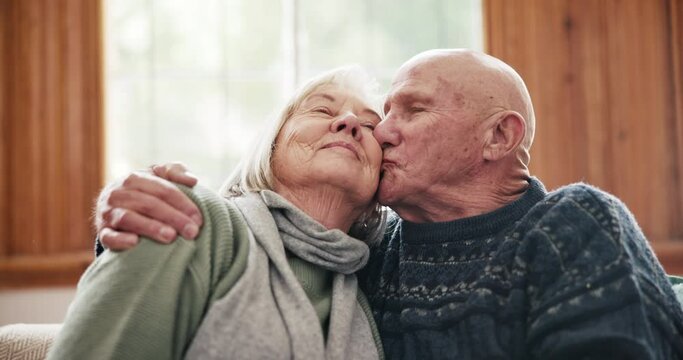 Hug, kiss and senior couple relax on a sofa with support, trust or gratitude in their home together. Love, security and old people embrace in a living room with care, romance or comfort in retirement