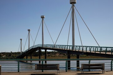 Picturesque bridge spans a body of water with benched nearby