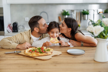 Happy family eating pizza at home