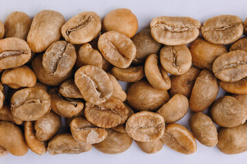 Macro fresh green raw roasting coffee beans, white isolated background