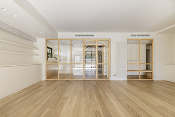 empty living room in a living room with wooden floors and a wall covered in glass and wood