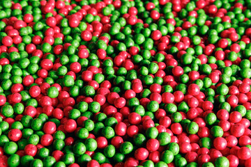 Closeup red and green color dragee, chocolate covered nuts, sweet candy background