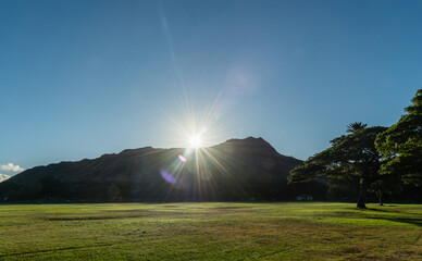 Scenic Kapiolani Regional Park vista in Honolulu, Hawaii, with sun rising over the Diamond Head mountain