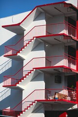 some red and white railings and a building that has red metal stair rails on