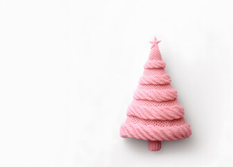 Christmas tree with a star on top, pastel pink knitting, creative copy space, winter holidays greeting card.