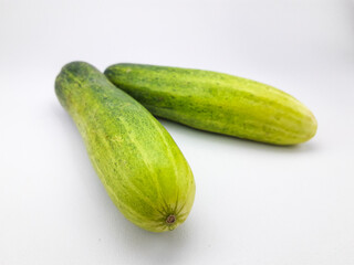 2 cucumbers isolated on a white background, this fruit contains a lot of water so it is very refreshing but tastes bland, can be eaten directly or cooked, often also used as a garnish or facial mask
