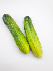 2 cucumbers isolated on a white background, this fruit contains a lot of water so it is very refreshing but tastes bland, can be eaten directly or cooked, often also used as a garnish or facial mask