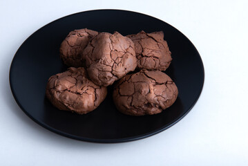 chocolate chip cookies on a black plate and white background