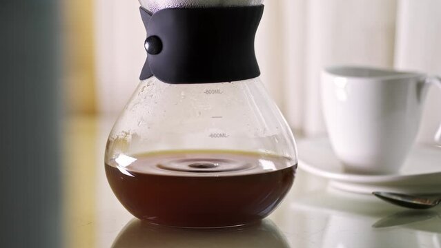 Dripping hot filter coffee in pot, macro 