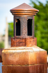 Fototapeta premium Traditional brick chimney stack situated on the side of a brick wall, with a tree in the foreground