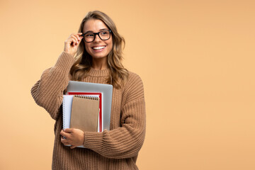 Smart smiling university student wearing stylish eyeglasses holding laptop and books isolated on...