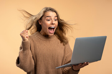 Young overjoyed woman holding laptop shopping online. Shopping, sale black Friday concept. Happy...