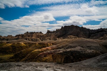 Obraz premium Landscape of hills under a cloudy sky in Badlands National Park, South Dakota