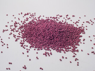 Cold cut terra cotta colored masterbatch granules on a white background, this material is used as a...