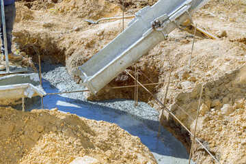 Worker pouring concrete foundation for new house at construction site