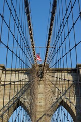 American flag waving atop the iconic Brooklyn Bridge located in New York City