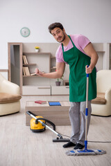 Young male contractor cleaning the house