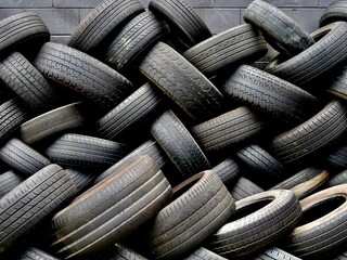 Pile of used black car tyres waiting to be recycled
