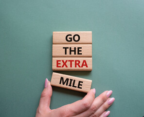 Go the extra mile symbol. Wooden blocks with words Go the extra mile. Businessman hand. Beautiful...