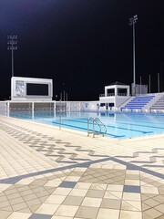 Nighttime shot of a swimming pool in bright light.