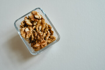 Raisins, nuts, dates in glass bowls on a white table. Concept of proper nutrition and sweets