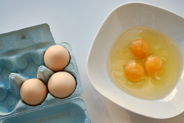Bowl of raw eggs and eggshells on white background. Eggs are a healthy food