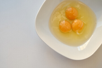 Bowl of raw eggs and eggshells on white background. Eggs are a healthy food