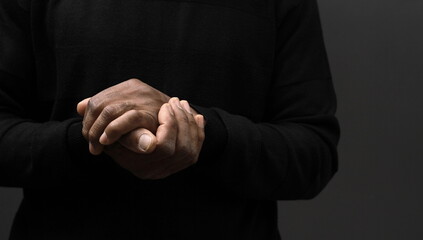 praying to God with hands together on grey black background with people stock image stock photo	