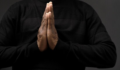 praying to God with hands together on grey black background with people stock image stock photo	