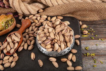 Pistachios briefly in copper bowl on wooden rustic background, wonderful pistachio composition for...