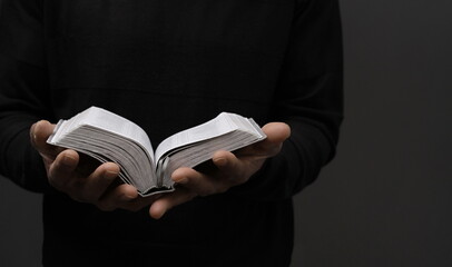 praying to God with hands together on grey black background with people stock image stock photo	