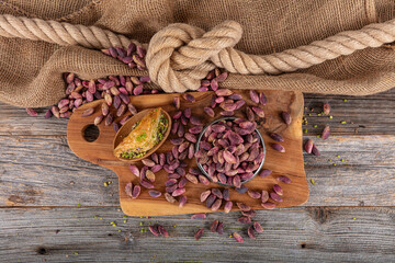 Fresh pistachios in copper bowl on wooden rustic background, wonderful peanut composition for healthy and dietary nutrition. Concept of fresh pistachios.