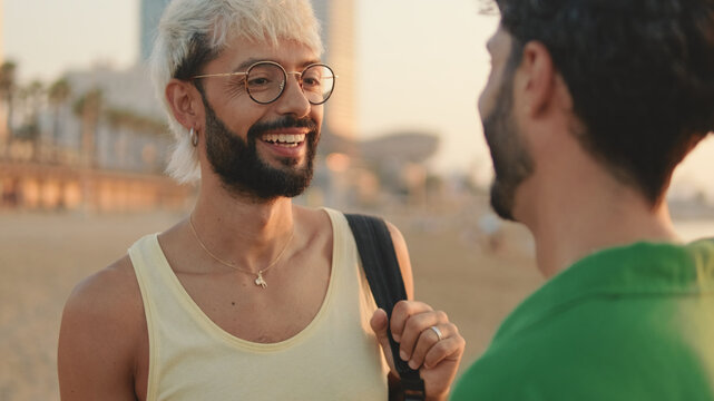 Young Happy Gay Couple Talking While Standing On The Beach