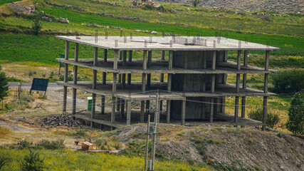 A multi-story building under construction in the heart of nature and in the middle of the mountains