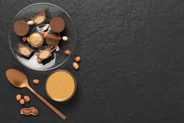 Delicious peanut butter cups with nuts on concrete background, top view