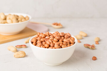 Peeled and unpeeled peanuts on concrete table