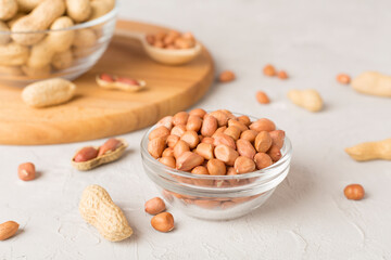 Peeled and unpeeled peanuts on concrete table