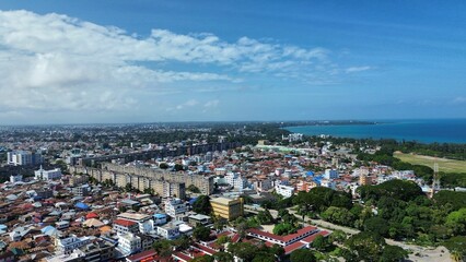 Aerial view of a cityscape against the sea on a sunny day